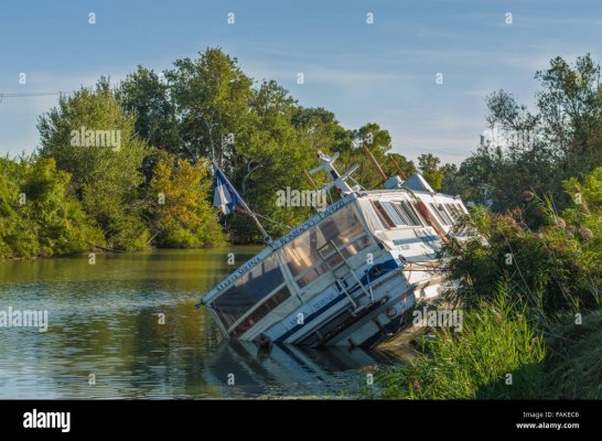A sunken wooden boat in a river in france FAKEC6